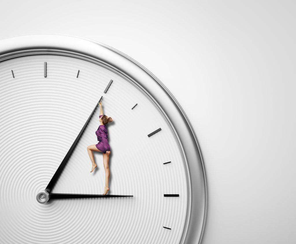 Skincare Secrets of the Stars: Celebrities Are Aging in Reverse—Here's Why 1 woman in a purple jumper standing on hour hand of clock and pushing minute hand backward